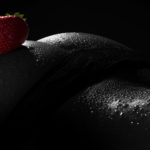 Erotisches Akt Fotoshooting: Rote Erdbeere auf sexy Hintern mit Wassertropfen