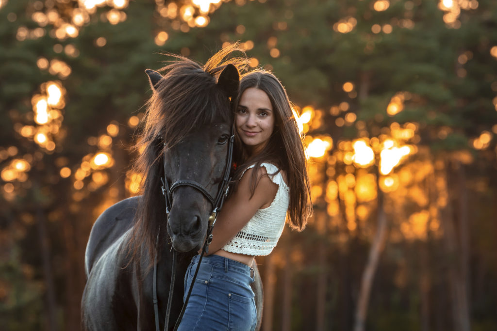 Mädchen mit Pferd im Sonnenuntergang